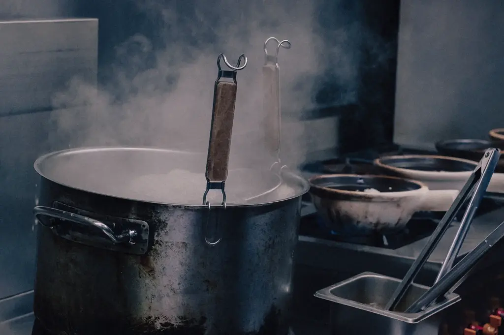 Commercial kitchen preparation of collagen-rich fish broth in a large stockpot, showcasing the traditional cooking process behind Singapore pomfret and threadfin fish soup.